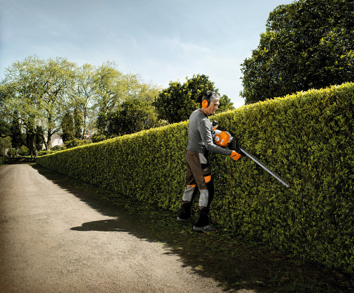 Operatore durante la rifinitura di una siepe con tosasiepi STIHL HS 87 T