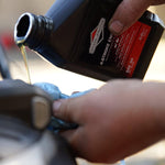 Manutenzione motore a 4 tempi: olio Briggs & Stratton SAE 30 versato in motore. Ideale per tagliaerba, trattorini e attrezzature da giardinaggio. Prodotto di alta qualità per prestazioni ottimali e lunga durata del motore.