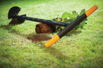 Trivella manuale Fiskars QuikDrill appoggiata su prato con impugnatura arancione