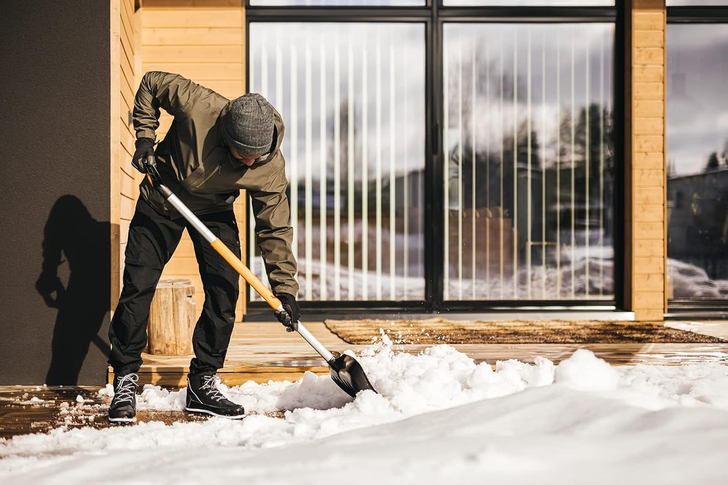 Spingineve Fiskars X-series in uso per liberare vialetto e terrazzo dalla neve