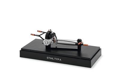 Modellino motosega d’epoca Stihl Typ A in scala 1:12 su basamento con cappuccio trasparente
