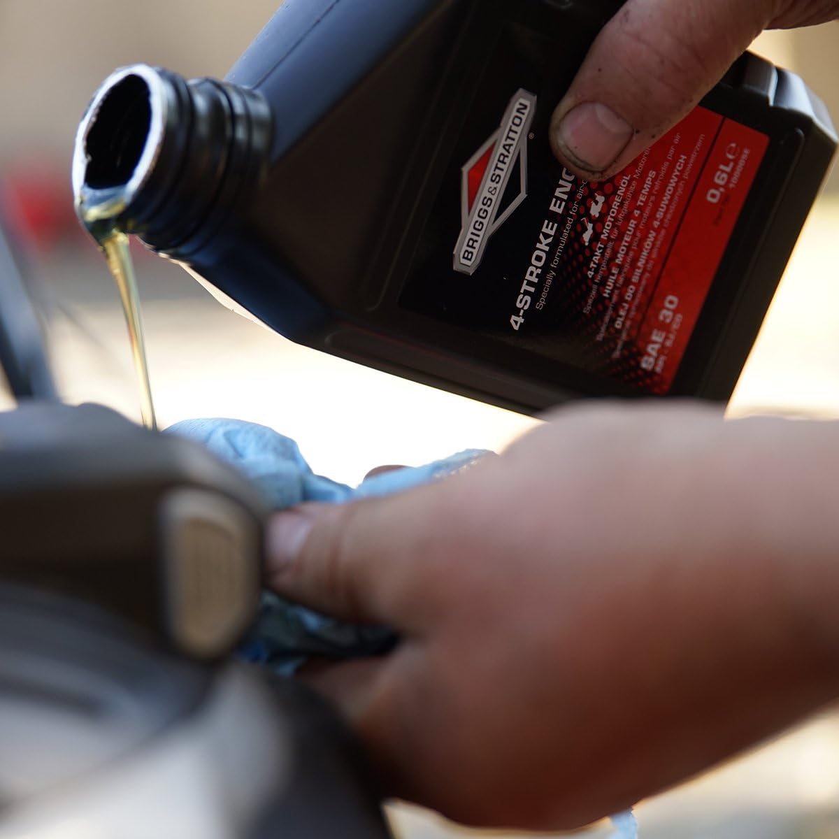 Olio motore Briggs & Stratton SAE 30 durante versamento per manutenzione motore