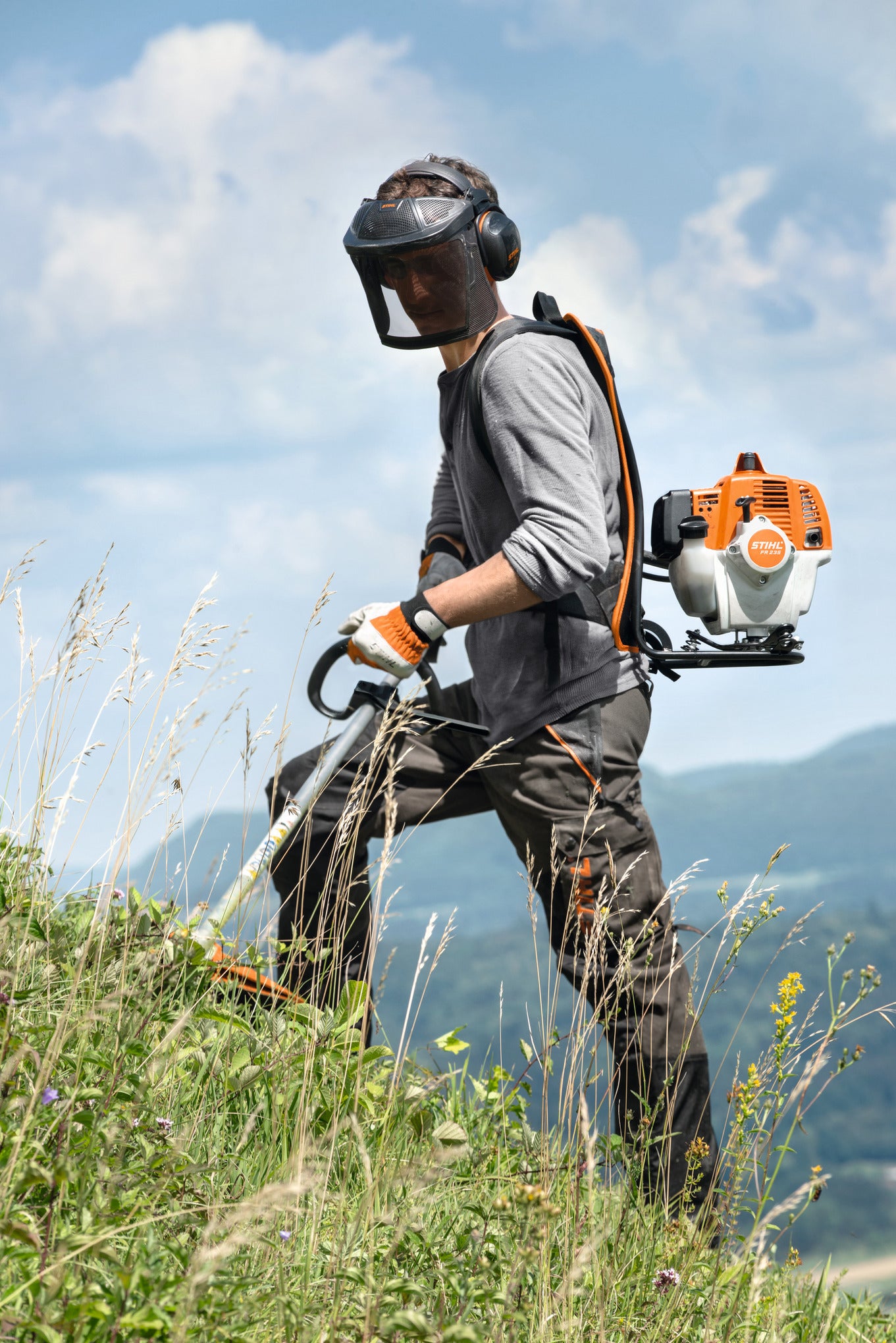 Operatore con decespugliatore spalleggiato Stihl FR 235 durante lo sfalcio di erba alta