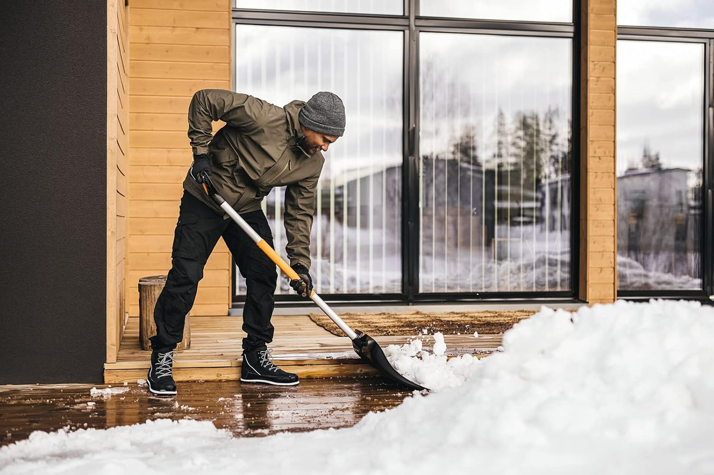 Spingineve Fiskars X-series in uso per spingere neve su superficie esterna