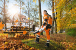 Operatore con soffiatore STIHL BGA 100 e batteria a zaino in lavoro su foglie in parco