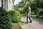 Operatore al lavoro con tagliasiepi allungato STIHL HL 91 KC-E per sagomatura siepi