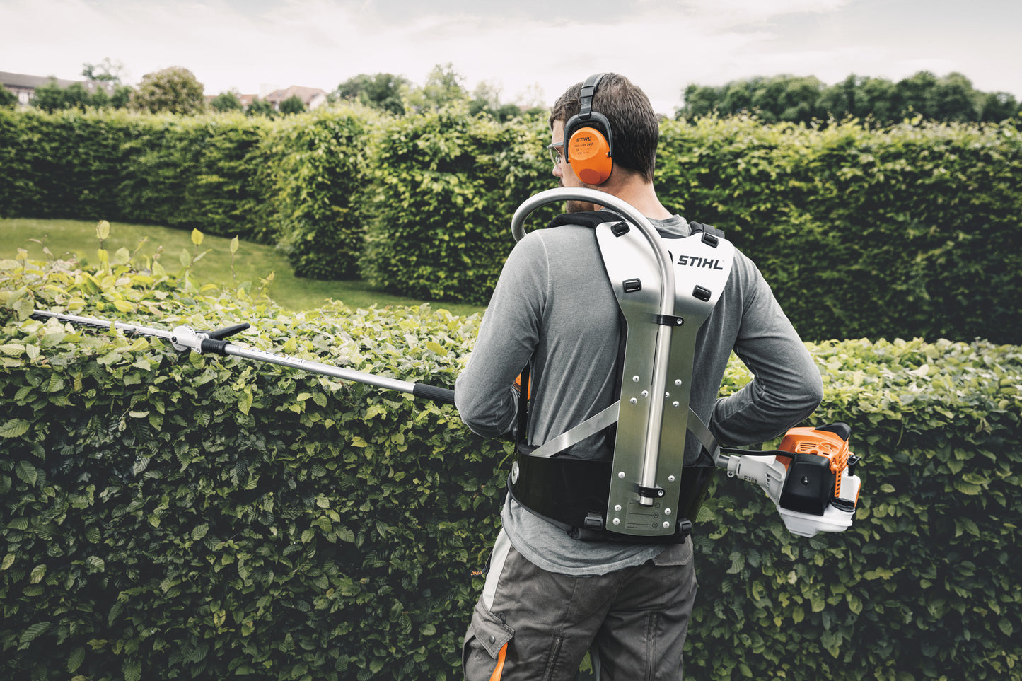 Operatore con tosasiepi allungato Stihl HL 94 C-E per potatura siepi alte