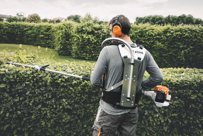 Operatore con tosasiepi allungato Stihl HL 94 C-E per potatura siepi alte