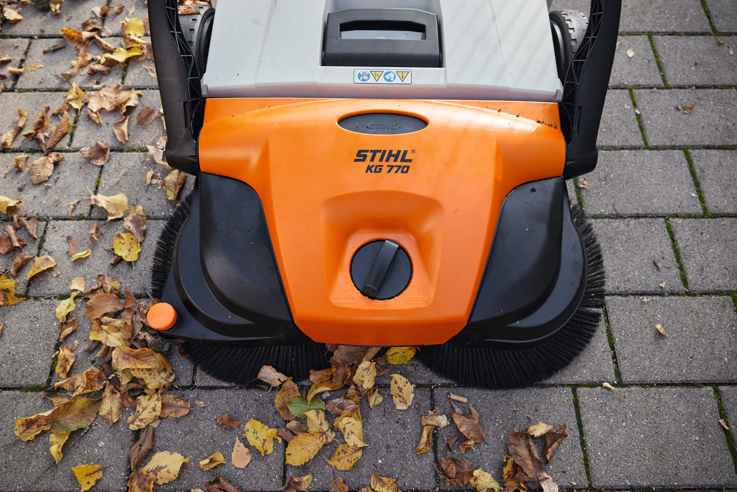 Vista dall’alto della spazzatrice manuale Stihl KG 770 su pavimentazione