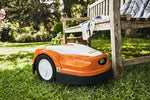 Robot tosaerba STIHL iMOW RMI 422 P vicino a panchina in giardino