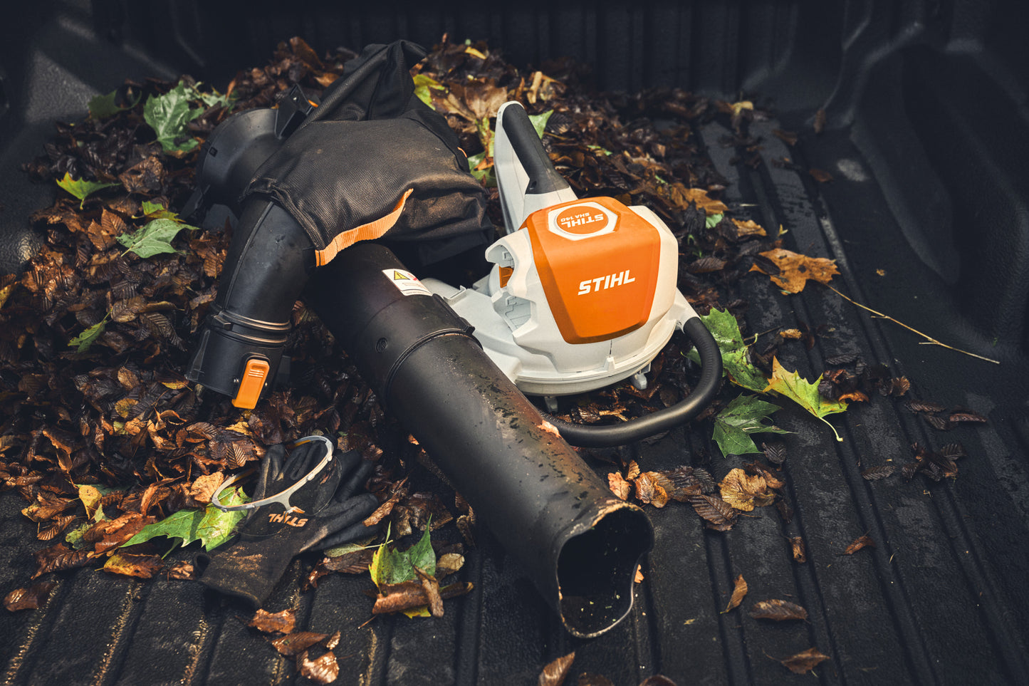 STIHL SHA 140 aspiratore trituratore a batteria appoggiato su foglie raccolte