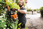 Operatore mentre utilizza il tosasiepi a scoppio Stihl su siepe